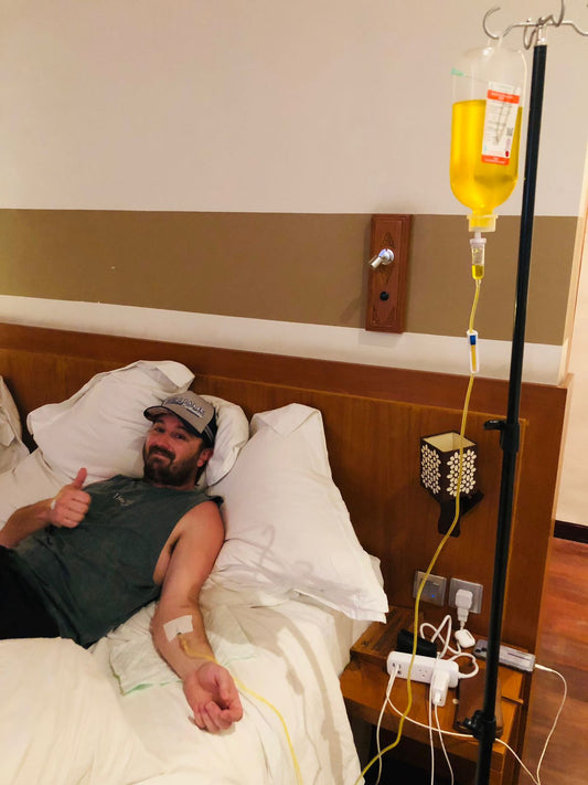 Group of friends recovering from hangover with IV drip at Bali villa